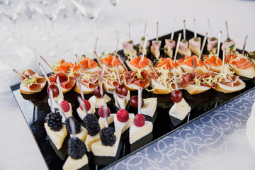 on a wooden table in the wedding banquet area are snacks, fruits, sweet cakes and muffins and lemonade drink