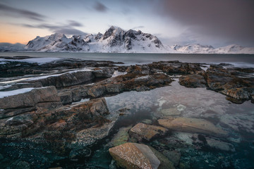 Soft tones of the golden hour in mountains at the coast of Vareid, Lofoten, Norway

