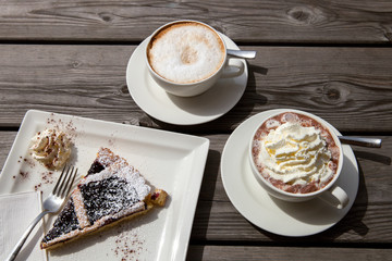 blueberry cake with whipped cream, cappuccino and coffee with whipped cream