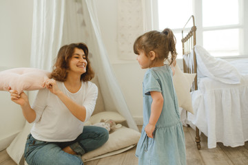 Obraz premium A young mother spends time with her little daughter at home.