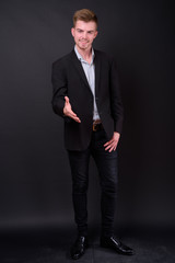 Portrait of young handsome blond bearded businessman in suit