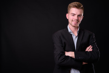 Portrait of young handsome blond bearded businessman in suit