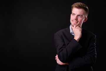 Portrait of young handsome blond bearded businessman in suit