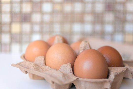Brown eggs in a cardboard tray top view. Selected focus.