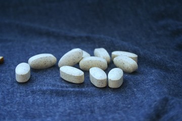 Fototapeta na wymiar Pills on dark blue background as pharmacy concept.