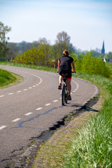 Naklejka premium One woman ride bicycle in Betuwe, Gelderland, Netherlands