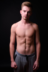 Fototapeta na wymiar Young handsome man shirtless against black background