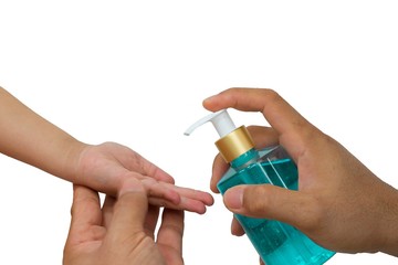 The hands of an adult hold the child's hand and press the alcohol pump into the child's hand. With Clipping Path.