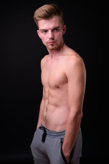 Fototapeta premium Young handsome man shirtless against black background