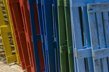 Obraz premium Row of wooden empty pallets painted in different colors, red, green, blue and yellow. 