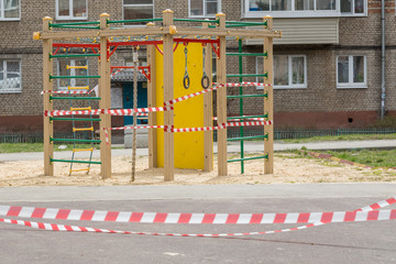 Fototapeta na wymiar An empty courtyard and a playground tied with prohibitive ribbons in Russia due to the global impact of COVID-19.