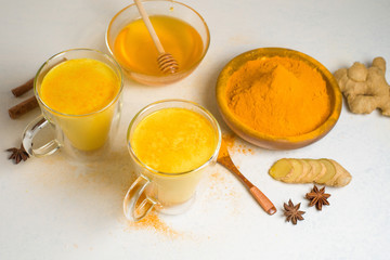 Indian traditional Golden milk with turmeric, ginger, spices, honey. healing effect of the drink. ingredients for a Golden drink on a light background. antiviral antioxidant. the view from the top
