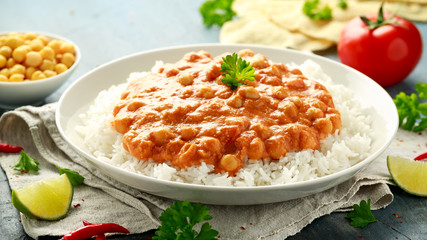 Spicy chickpeas curry with rice, tomato and Poppadoms in white plate. Healthy tasty vegetarian food