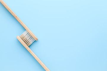 Zero waste and no plastic concept. Two eco friendly bamboo toothbrushes on a light blue surface. Top view, copy space. Layout natural organic hygiene products.