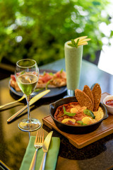 Breakfast with shakshuka and bruschetta and smoothie and glass of wine