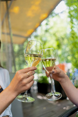 Clink glasses with white wine on terrace