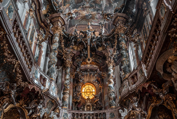 Ornate Second floor  of altar with crucifix inside Baroque church Asamkirche in Munich, Germany