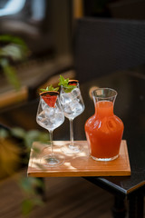 Grapefruit lemonade with glasses on wooden board