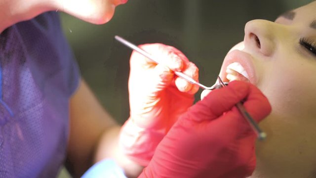 Female dentist doing dental treatment to her patient in clinic