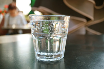 One glass of sparkling water isolated on black table