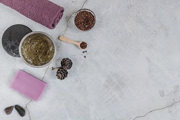 On a gray background are accessories for Spa self-care: body scrub, ground coffee, lavender soap, Terry towels for face and body