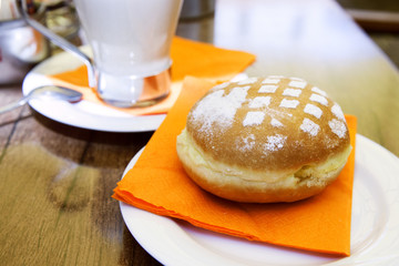 A donut with powdered sugar on table in cafe