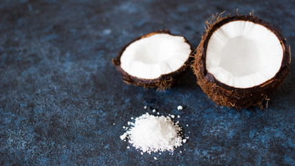 two halves of coconut on textured concrete blue marble background
