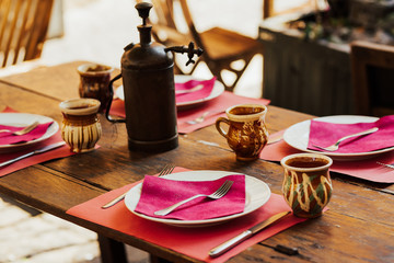 Outdoor restaurant in Italy. Empty glasses set in cafe. Food, travel and vacation concept. Cafe table  outside in a quaint corner of Italy. Empty tables at an outdoor restaurant. Exterior of cafe.