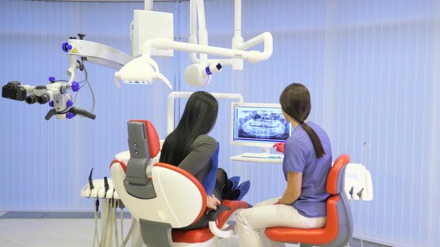 Female dentist shows on the monitor the healthy teeth of the patient