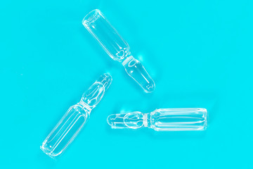 Naklejka premium Ampoule on a blue background with close-up. COVID-2019