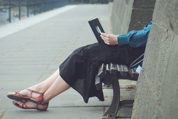 Girl reads a book on a bench