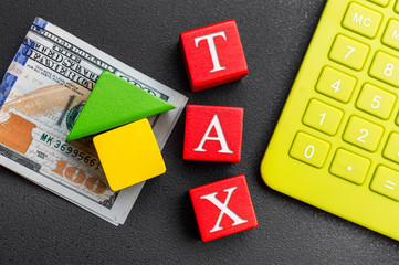 House from toy blocks with money, calculator and word 