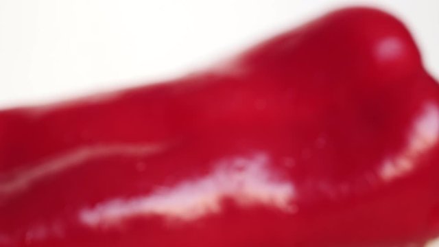 Rotating Fresh Raw Ramiro Red Chili Pepper On A White Plate With Drops Water.