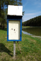 Empty information board near the pond