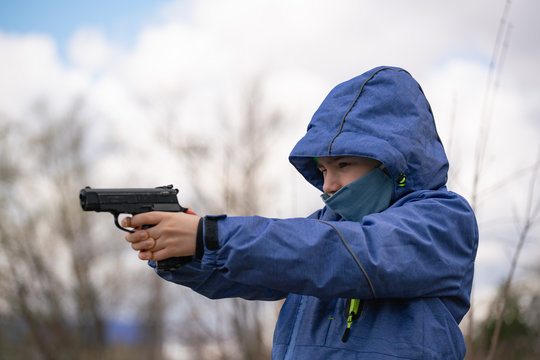 child aiming with a pistol, holding it at arms outstretched