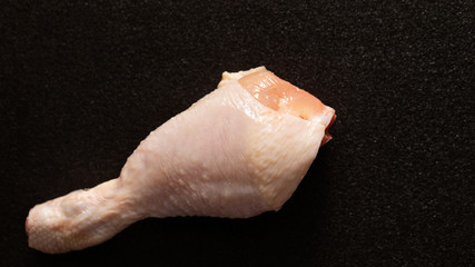 Raw chicken leg on black background 