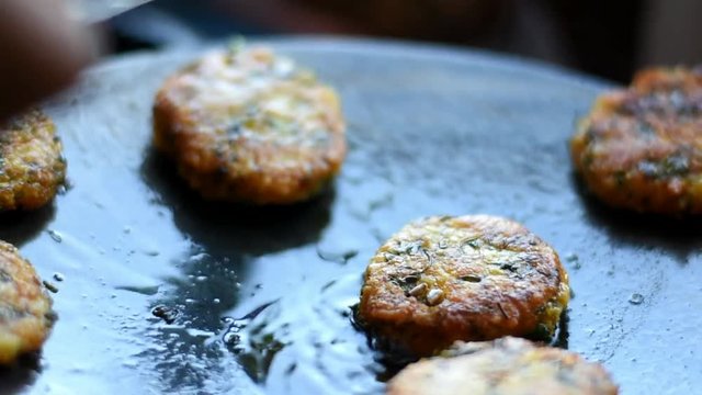 woman making a indian pakode in a fry pen, with oil and potato, Indian Tikki