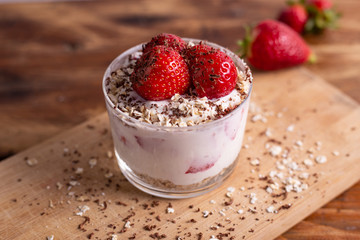 Yogurt with oat, strawberries, chocolate and almonds. Healthy and nutritious snack. Oatmeal yogurt, good protein food for muscles.