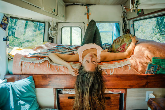 Girl laying on a bed in a camper van