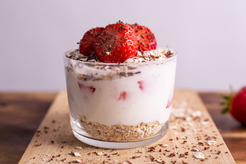 Yogurt with oat, strawberries, chocolate and almonds. Healthy and nutritious snack. Oatmeal yogurt, good protein food for muscles.