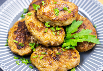 fresh meat fried cutlets with greens on a plate, close-up. brutal men's food
