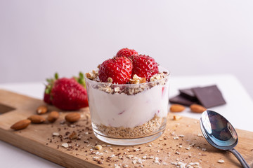 Yogurt with oat, strawberries, chocolate and almonds. Healthy and nutritious snack. Oatmeal yogurt, good protein food for muscles.