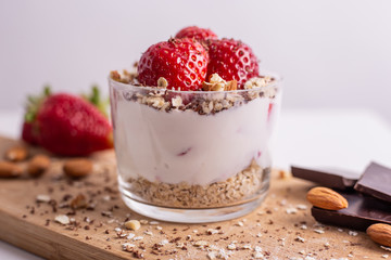 Yogurt with oat, strawberries, chocolate and almonds. Healthy and nutritious snack. Oatmeal yogurt, good protein food for muscles.