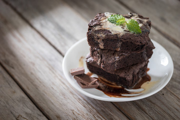 Chocolate brownies stacks on wooden background, homemade sweet and dessert
