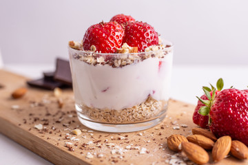 Yogurt with oat, strawberries, chocolate and almonds. Healthy and nutritious snack. Oatmeal yogurt, good protein food for muscles.