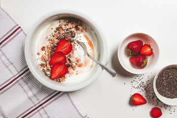 top view of yogurt bowl with muesli strawberries chia seeds