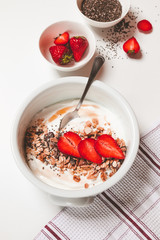 breakfast table with yogurt bowl strawberries muesli chia seeds