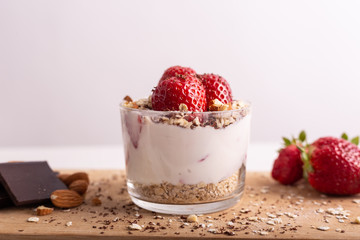 Yogurt with oat, strawberries, chocolate and almonds. Healthy and nutritious snack. Oatmeal yogurt, good protein food for muscles.