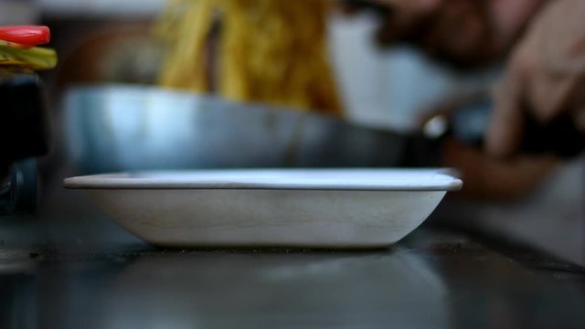 boy pouring a maggie in a white bowl with shallow depth of field