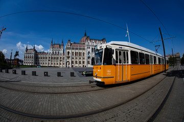 Fototapeta na wymiar A wide angle view of the east side of the Hungarian Parliament Building with the yellow line train and riders